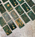 Collection of tarot cards with astrological symbols on a textured surface