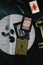 Decorative playing cards with mystical elements on a dark surface