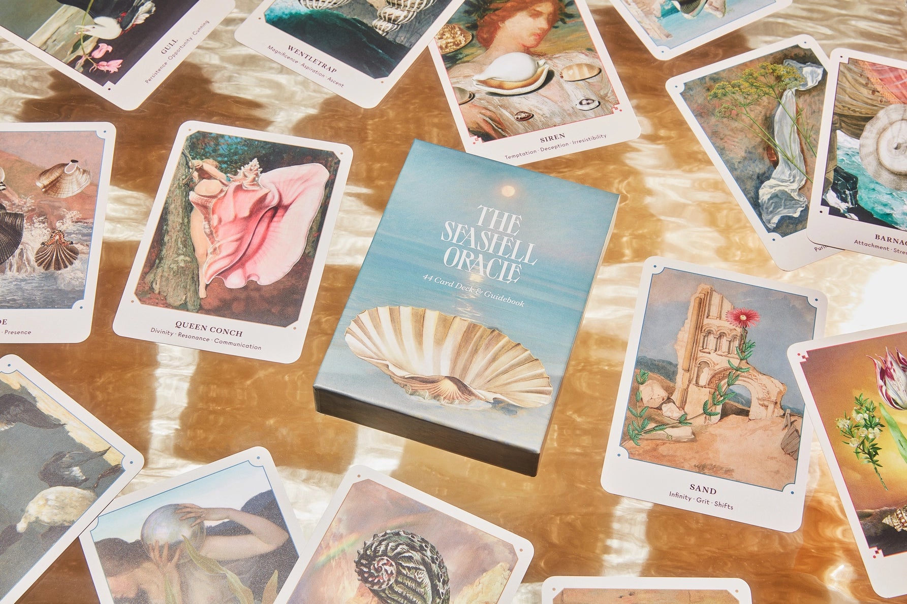 Tarot cards and 'The Senses' Oracle book on a wooden surface