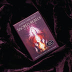 Sacred Rebels Oracle card deck on a dark fabric background