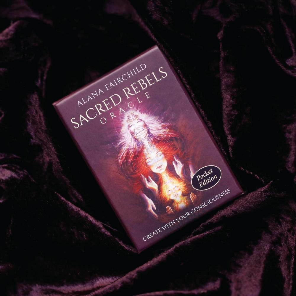 Sacred Rebels Oracle card deck on a dark fabric background