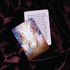 Card with artistic design and text on a dark fabric background