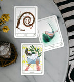 Three tarot cards on a marble surface with decorative elements.