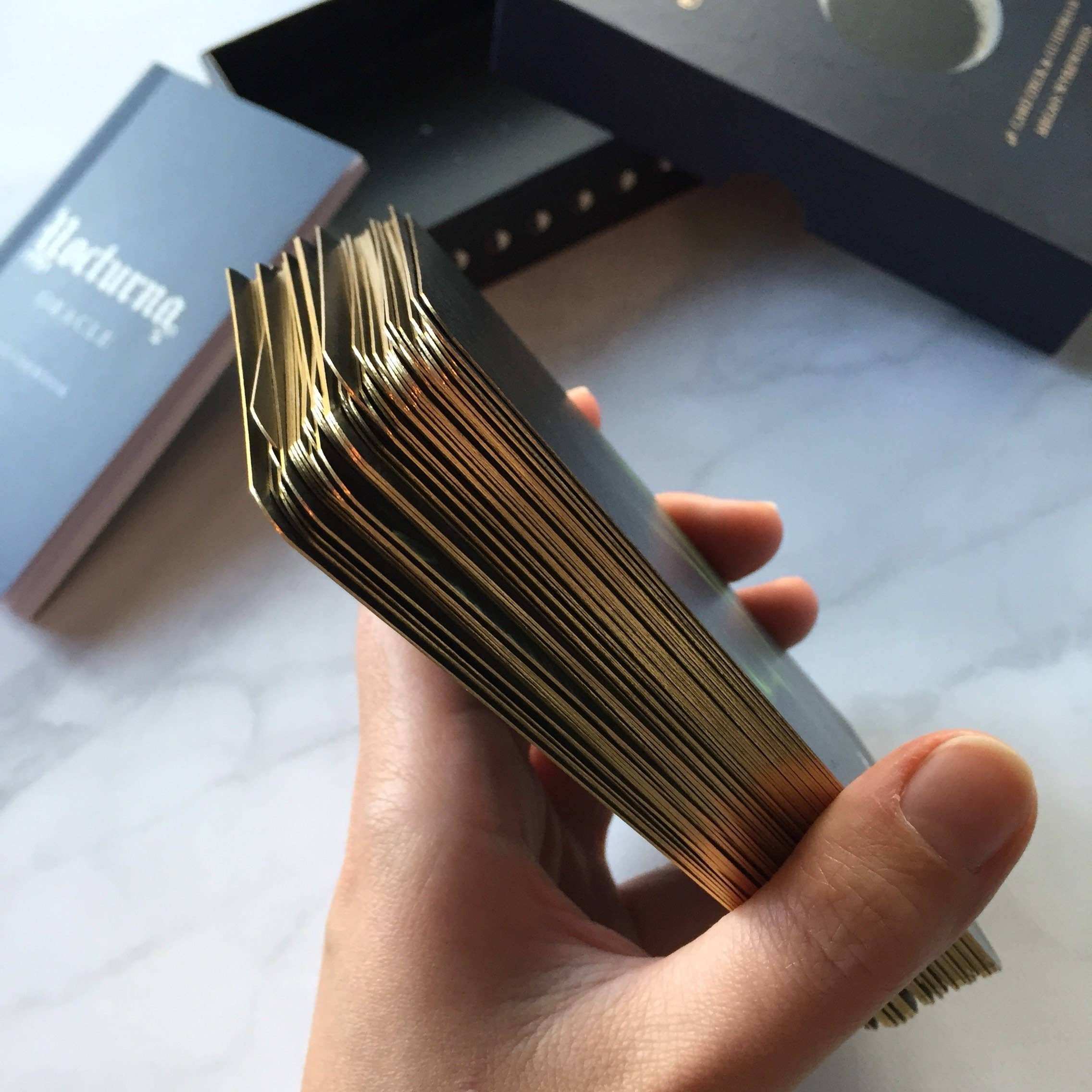Hand holding a deck of cards with a blurred background