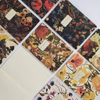 Collection of notebooks with floral designs and visible brand name.