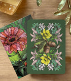 Two floral cards on a wooden surface with decorative elements.