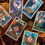 Collection of tarot cards with artistic illustrations on a wooden surface.