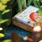 Mushroom Folk Oracle card deck on a blue surface with green leaves in the background