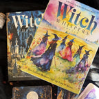 Two books titled 'Witch Whisper' and 'Witch' on a wooden surface.