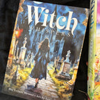 Book titled 'Witch Whispers' with a cover illustration of a witch in a cemetery.