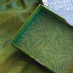 Green box with leaf pattern on a green leafy background