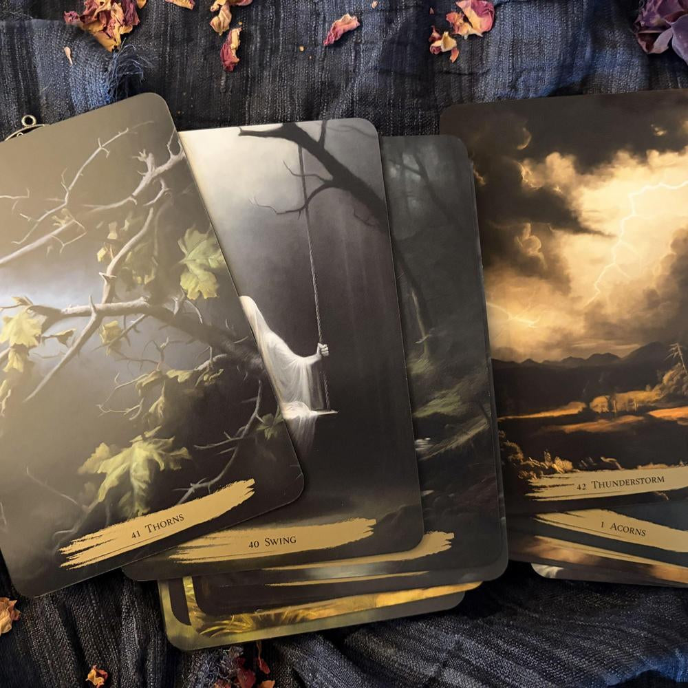 Set of tarot cards with nature-themed illustrations on a textured surface.