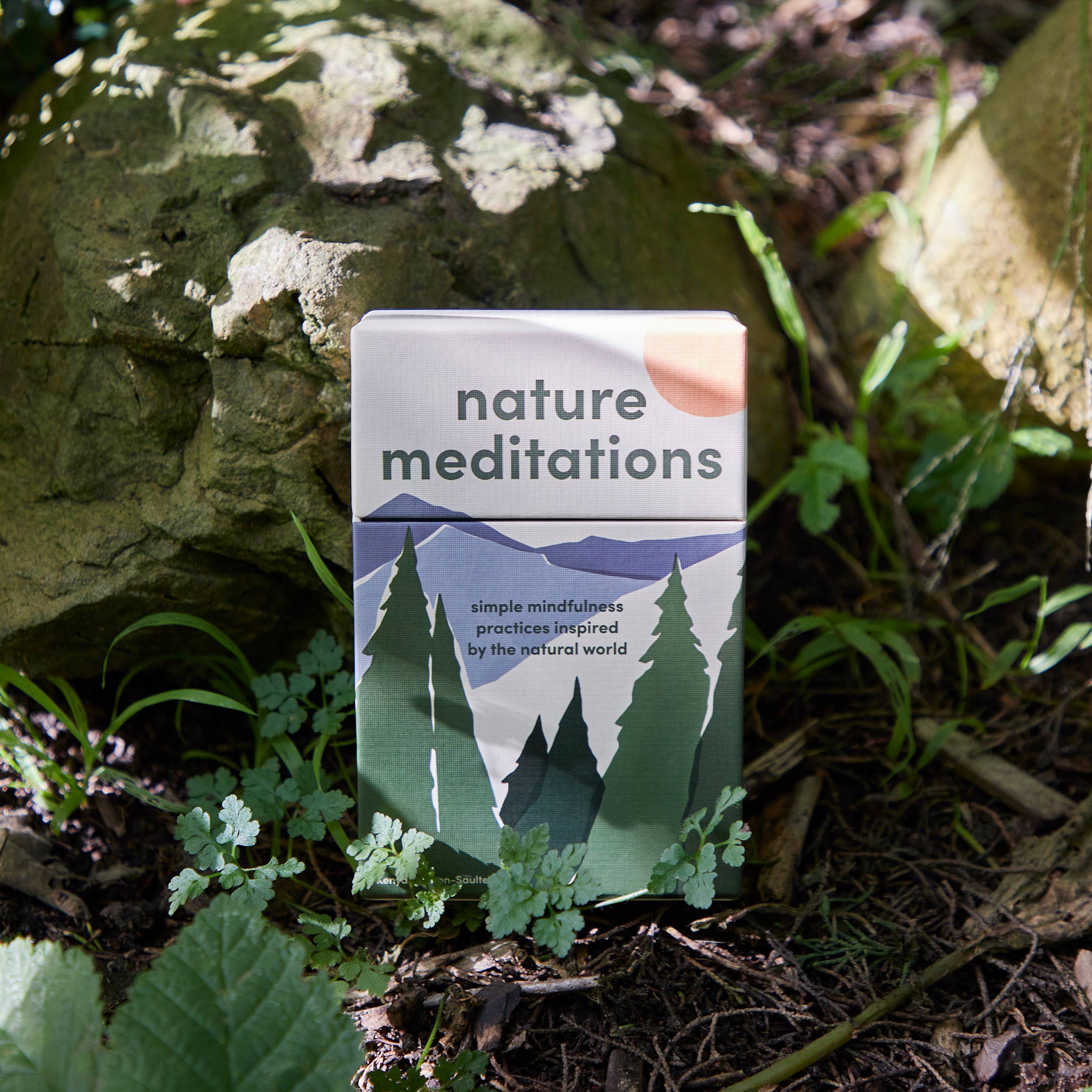 Pack of 'nature meditations' cards on a natural background with trees and rocks.