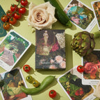 Garden Oracle cards with vegetables and a rose on a green surface