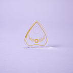 Teardrop-shaped object with gold design on a light purple background