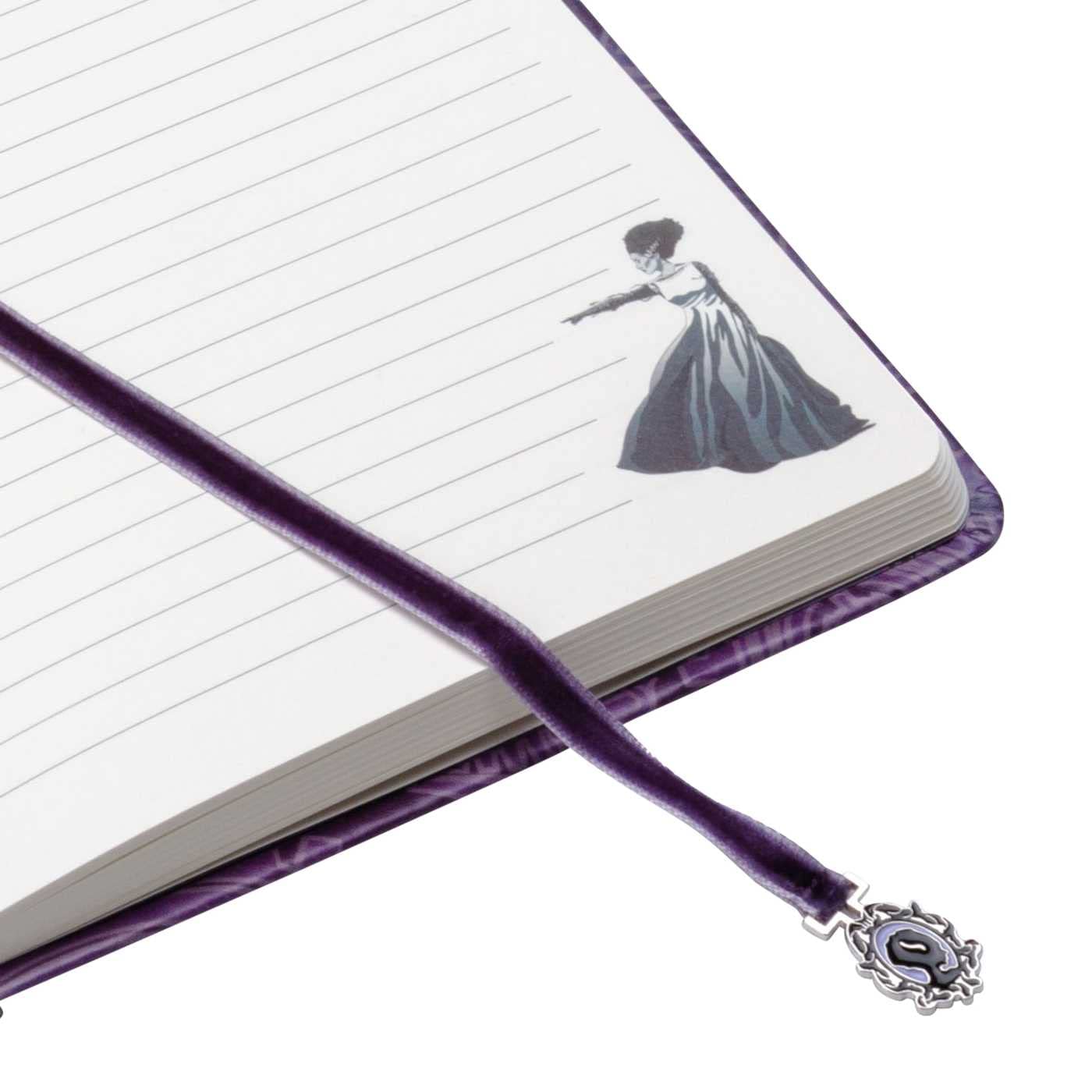 Notebook with a purple ribbon bookmark featuring a decorative clasp on a white background