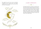 A printed page from a card deck or spiritual guidebook with text about card spreads and a decorative illustration showing a gold crescent moon, clouds, and a sun over water.