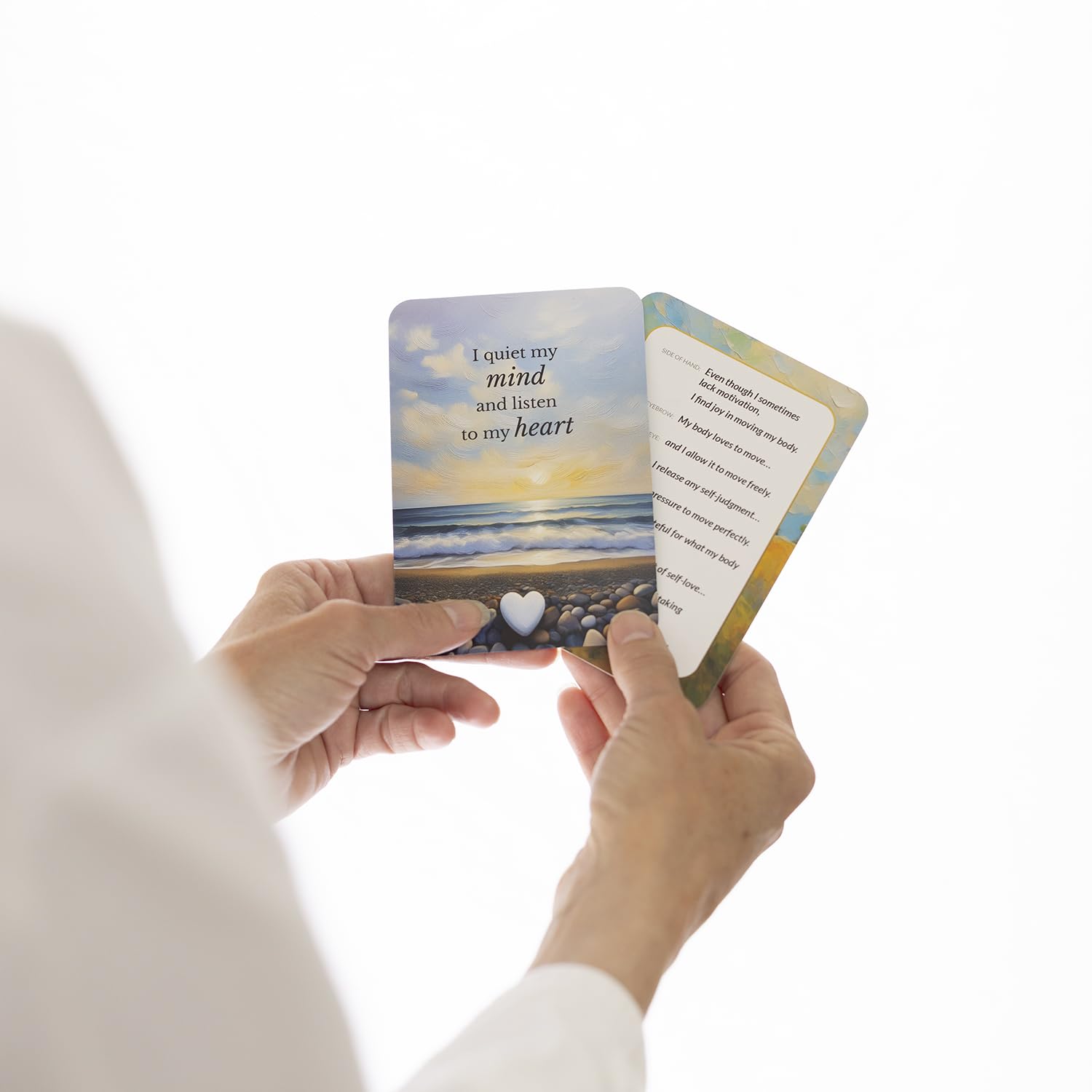 Person holding a card with a scenic design and text on a white background
