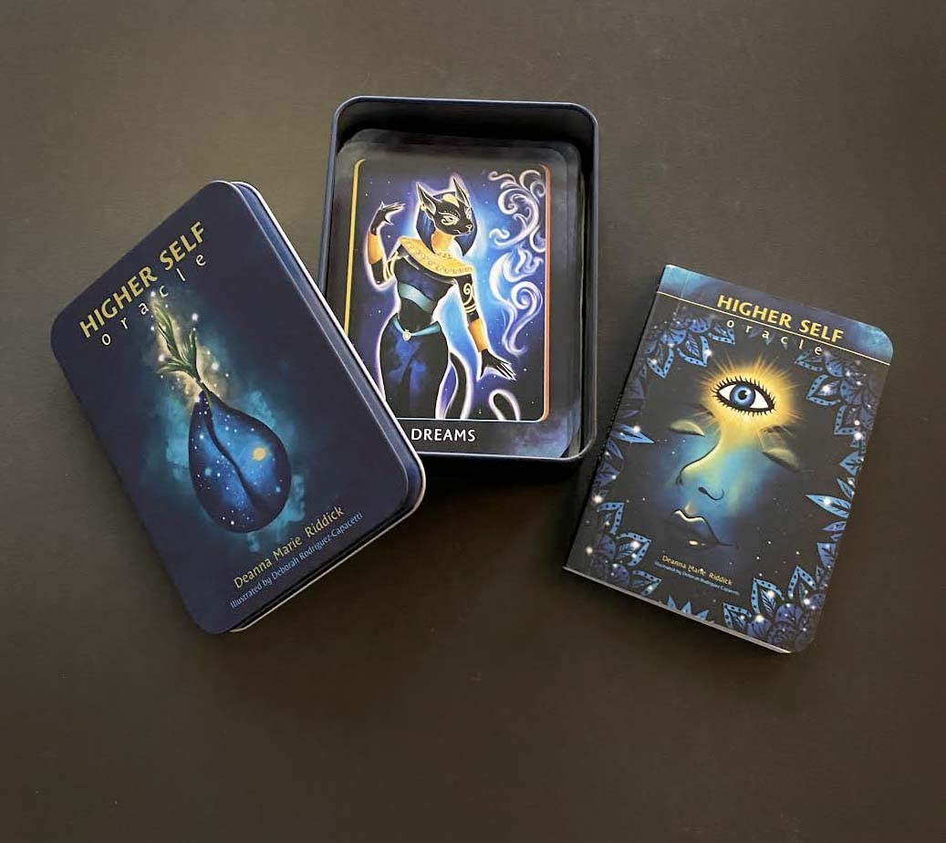 Three tarot cards from the 'Higher Self' deck on a dark surface
