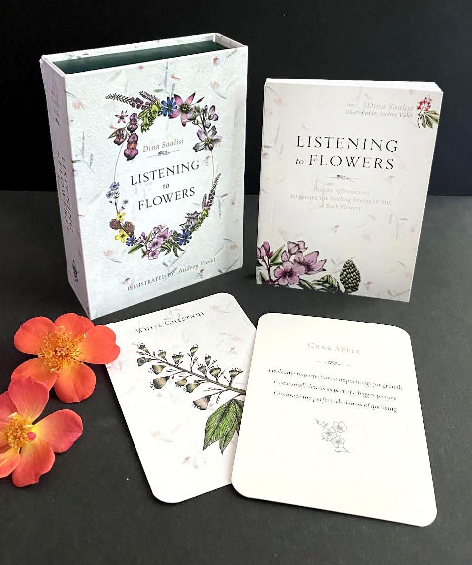 Set of 'Listening to Flowers' books and cards on a dark surface with flowers.