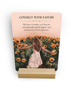 Card with a woman in a dress standing in a sunflower field and text about connecting with nature.