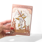 Hand holding a 'Sow the Magic' marshmallow salt soak packaging with floral design.