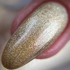 Close-up of a glittery nail polish swatch on a pink background
