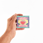 A hand holding a square mint package labeled 'THE LOVERS' and 'LAVENDER MINT' against a plain white background.