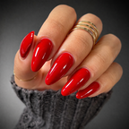 Hand with red nail polish and gold rings on a dark background