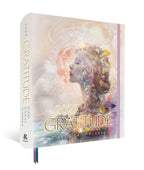 A 2027 Gratitude Diary & Daily Planner by Regan Books, shown standing upright at a slight angle. The cover features a dreamy, pastel-toned double-exposure illustration of a woman's profile with a glowing moon, clouds, and small gold decorative elements.