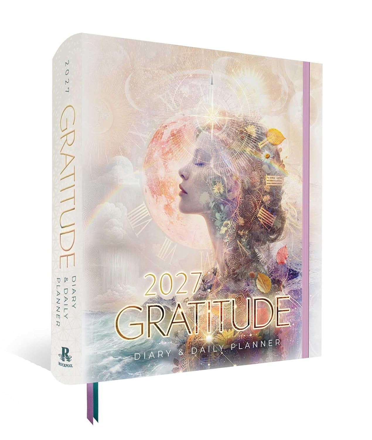 A 2027 Gratitude Diary & Daily Planner by Regan Books, shown standing upright at a slight angle. The cover features a dreamy, pastel-toned double-exposure illustration of a woman's profile with a glowing moon, clouds, and small gold decorative elements.