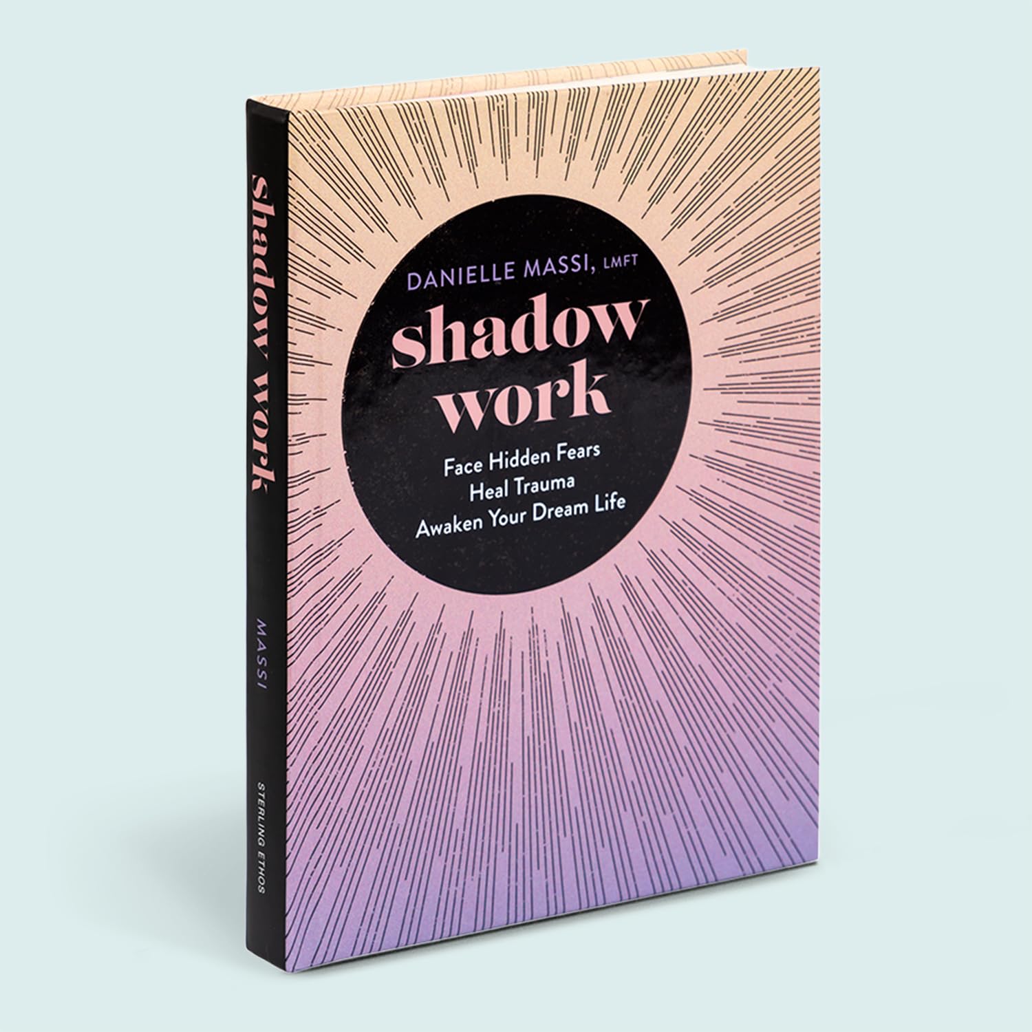 The book 'Shadow Work' by Danielle Massi, LMFT, standing upright at a slight angle. The cover features a black central circle with pink and white text, surrounded by a sunburst pattern of thin black lines transitioning from a warm beige/peach at the top to a lavender-purple at the bottom.
