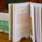 Open book with text and illustrations on a wooden surface