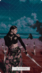 Woman holding swords on a beach with a mystical sky, tarot card titled '3 of Swords'.