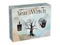A boxed calendar titled "Year Witch" by Temperance Alden, shown at a slight angle on a plain white background. The front features a light blue and beige design with a black tree, a black candle, a black handprint with gold details, and the text "2027 Calendar" and "Daily Intuitive Magick.