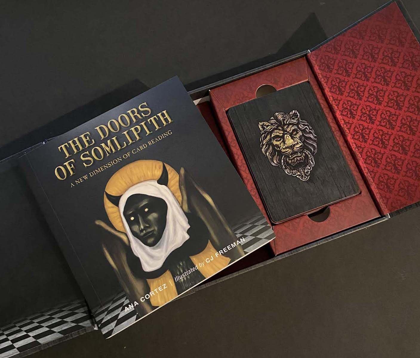 Card deck packaging with illustration and text on a dark surface
