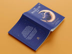 Open book with a blue cover featuring a cat and moon illustration on an orange background