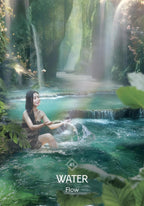 Woman sitting by a waterfall in a lush green forest
