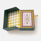 Open green box with a yellow checkered interior and a decorative card on a white background