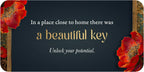 Decorative key fob with red flowers and motivational quote on a dark background