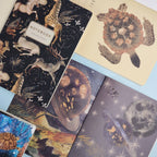 Collection of notebooks with various designs including animals and celestial patterns.