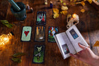 Tarot cards on a wooden table with a book and candles, creating a mystical atmosphere.
