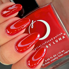 Red nail polish with a bottle of Luna nail polish in the background