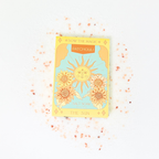 Decorative soap packaging with sun design and text on a light background