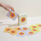 Card game with colorful cards and a box on a light surface
