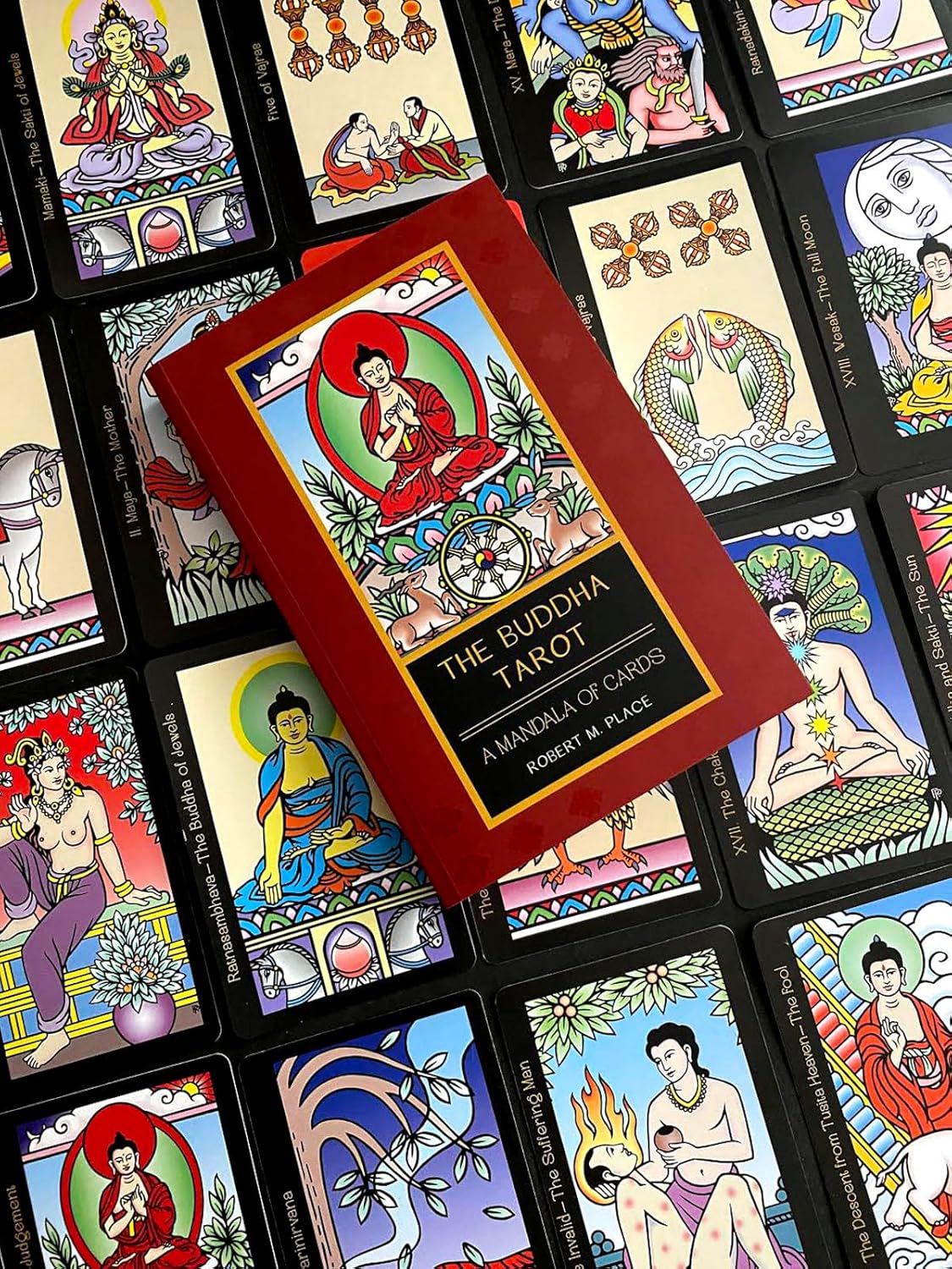 Collection of tarot cards featuring Buddha illustrations with a book titled 'The Buddha Tarot' on top.