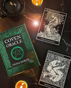 Coven Oracle book by Fiona Horne with tarot cards on a dark surface with candles.