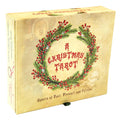 A boxed card game titled "A Christmas Tarot" shown at a slight angle on a white background. The box has a vintage cream-beige cover with a green pine wreath and red berries surrounding the title in red lettering.