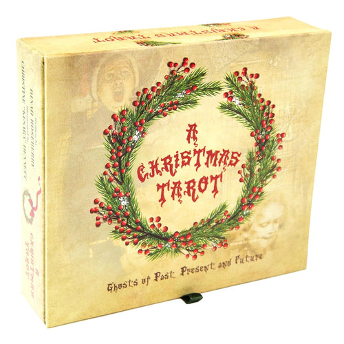 A boxed card game titled "A Christmas Tarot" shown at a slight angle on a white background. The box has a vintage cream-beige cover with a green pine wreath and red berries surrounding the title in red lettering.