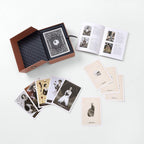 Collection of playing cards and a book on a white surface